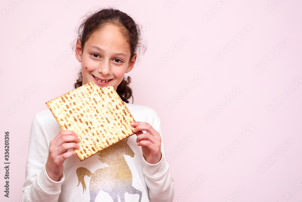 Portrait of the cute teenager girl holding matzah. Jewish child eating matzo unleavened bread in Jewish holidays Passover. Portrait of the cute teenager girl holding matzah. Jewish child eating matzo unleavened bread in Jewish holidays Passover.