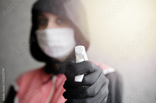 Tired disinfector in a protective suit and mask sprays disinfectants in house or office. Protection agsinst COVID-19 disease. Prevention of spreding pneumonia virus with surfaces. Coronavirus Pandemi photo