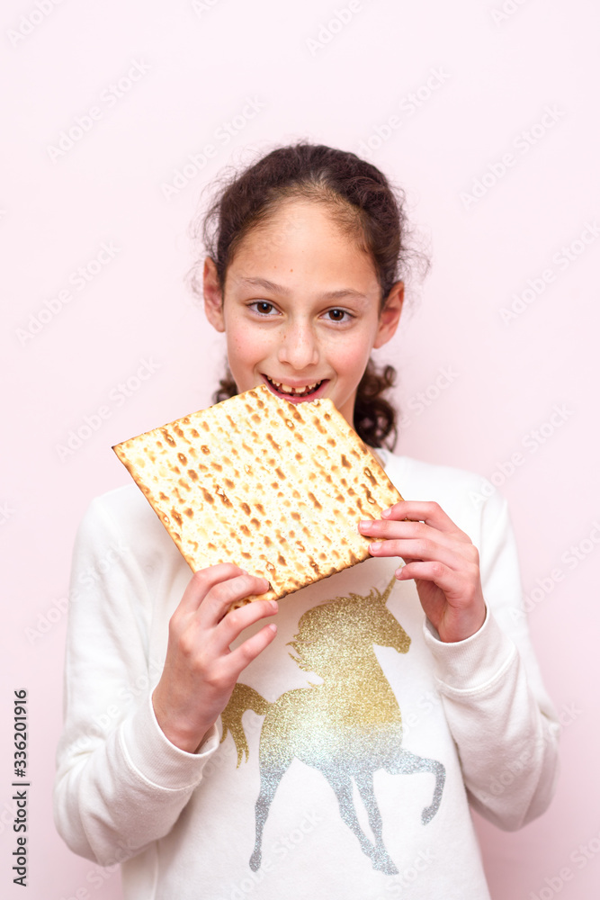 Portrait of the cute teenager girl holding matzah. Jewish child eating matzo unleavened bread in Jewish holidays Passover. Portrait of the cute teenager girl holding matzah. Jewish child eating matzo unleavened bread in Jewish holidays Passover.