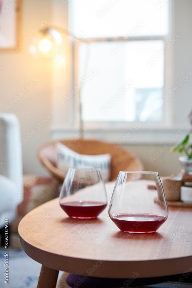 Two glasses of red wine in focus in a living room setting Two glasses of red wine in focus in a living room setting