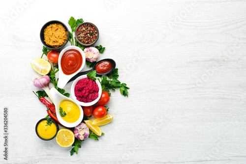 Set of sauces and spices on white wooden background. Top view.