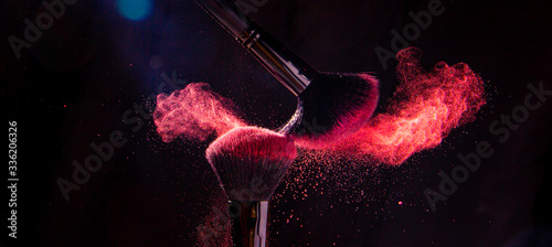 Colorful explosion on makeup brushes on a black background