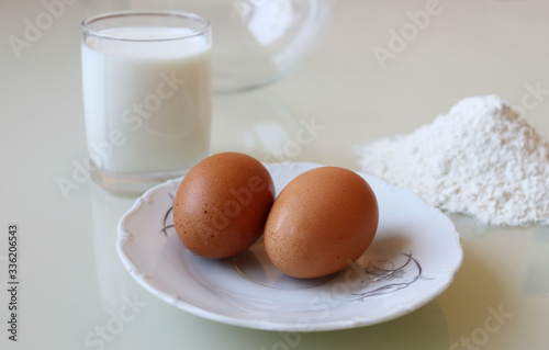 eggs, a glass of milk and flour for cooking