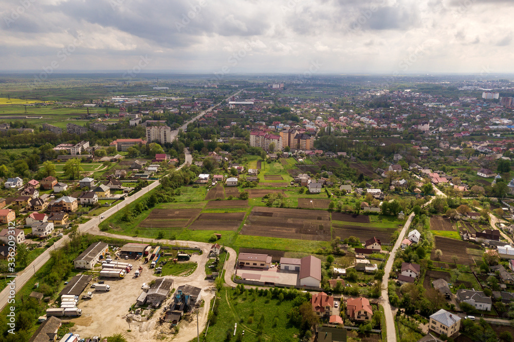 Aerial landscape of small town or village with rows of residential homes and green trees.