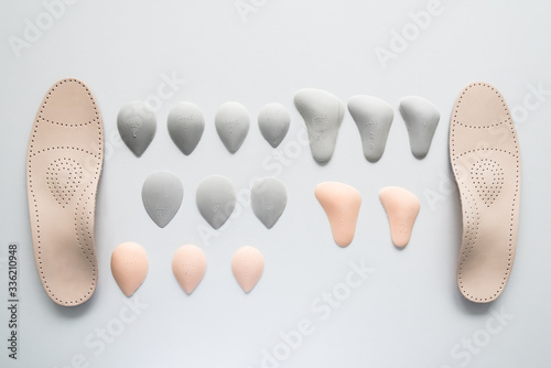 A pair of leather orthopedic insoles surrounded by components. Pelots for unloading the cross arch of different shapes and sizes. Choice. photo