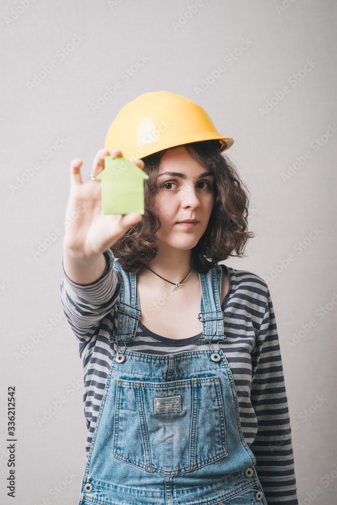 girl in the construction helmet and suit holding a cardboard house girl in the construction helmet and suit holding a cardboard house