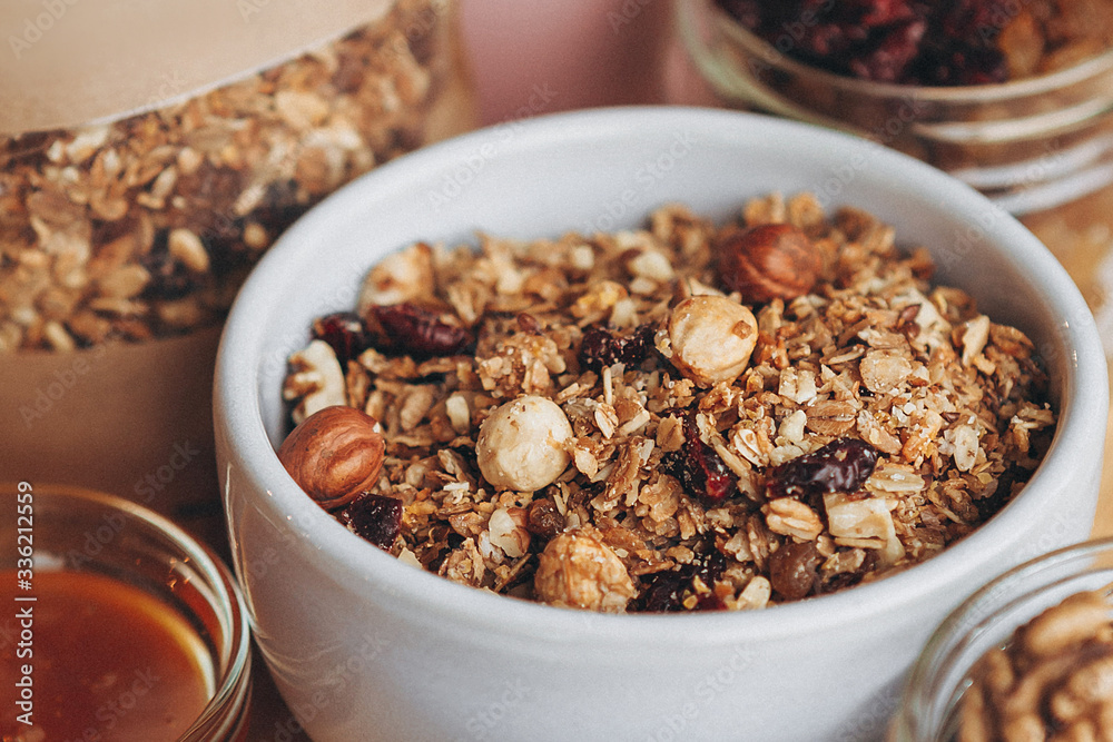 a delicious and crunchy oatmeal granola with honey, nuts, dried fruits and grains. Dynamic healthy food photography a delicious and crunchy oatmeal granola with honey, nuts, dried fruits and grains. Dynamic healthy food photography