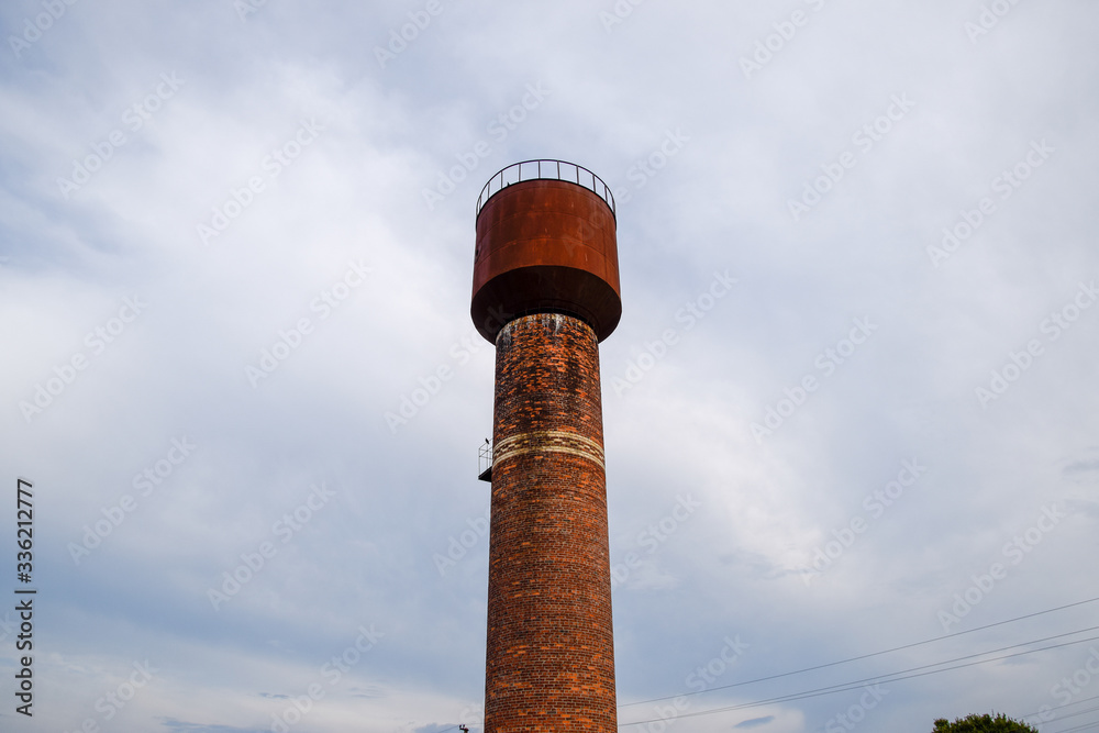 Rusty water tower against sky. Old water pump. Rusty water tower against sky. Old water pump.