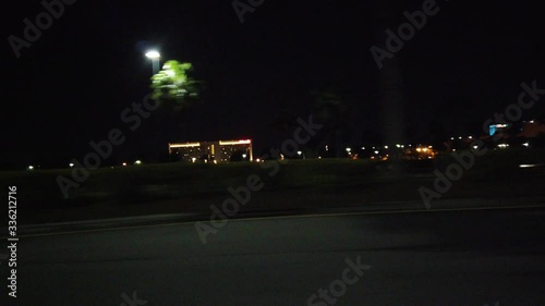 Side View Driving At Night Past Buildings With Palm Trees Hotels On Highway Freeway