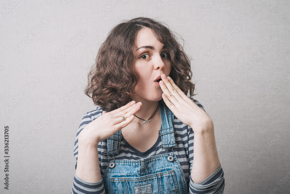 Woman embarrassed, wearing a jumpsuit Woman embarrassed, wearing a jumpsuit