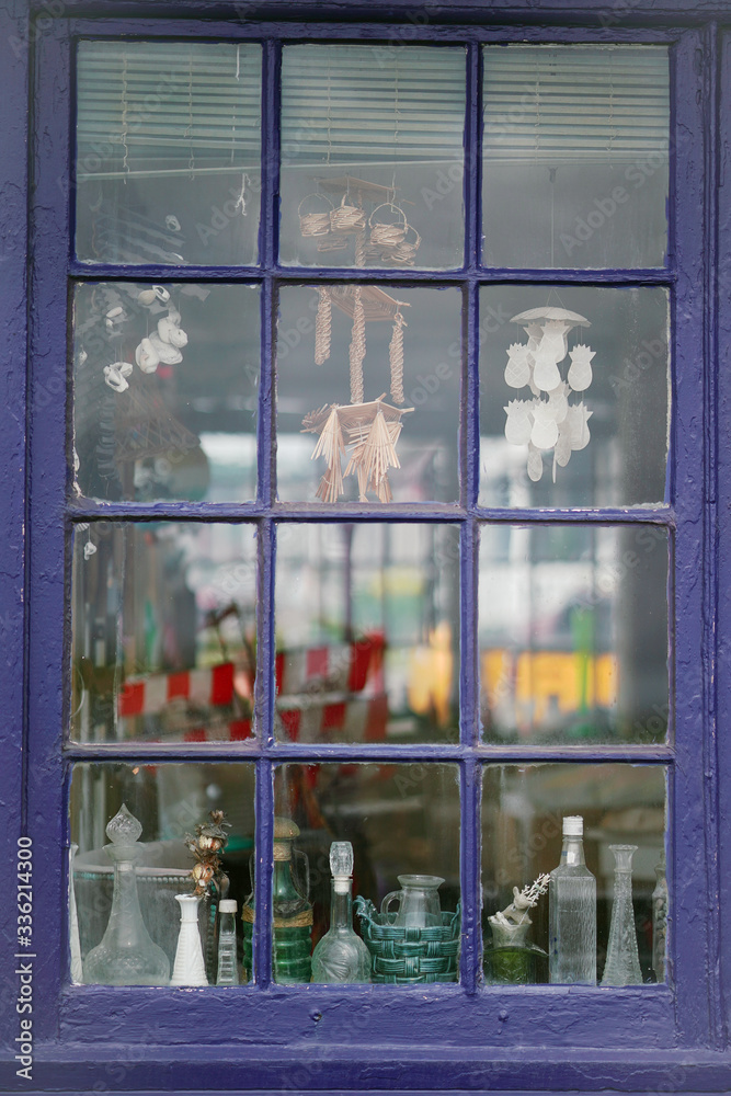 view inside a beach house window with collections of jars and shells ...