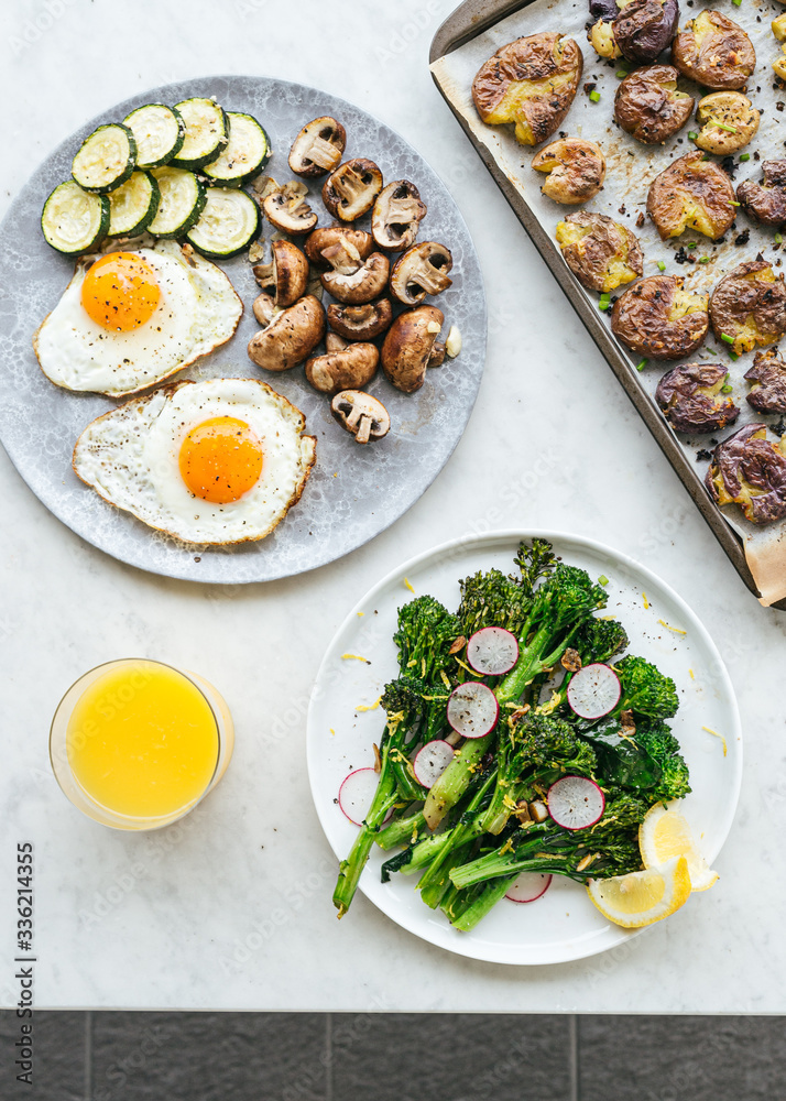 Brunch with fried sunny-side egg, vegetables, potatoes and orange juice Brunch with fried sunny-side egg, vegetables, potatoes and orange juice