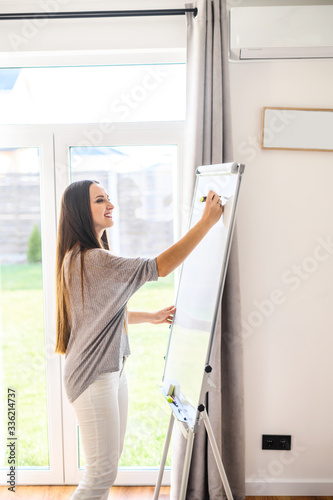 Young woman with flipchart records video lessons