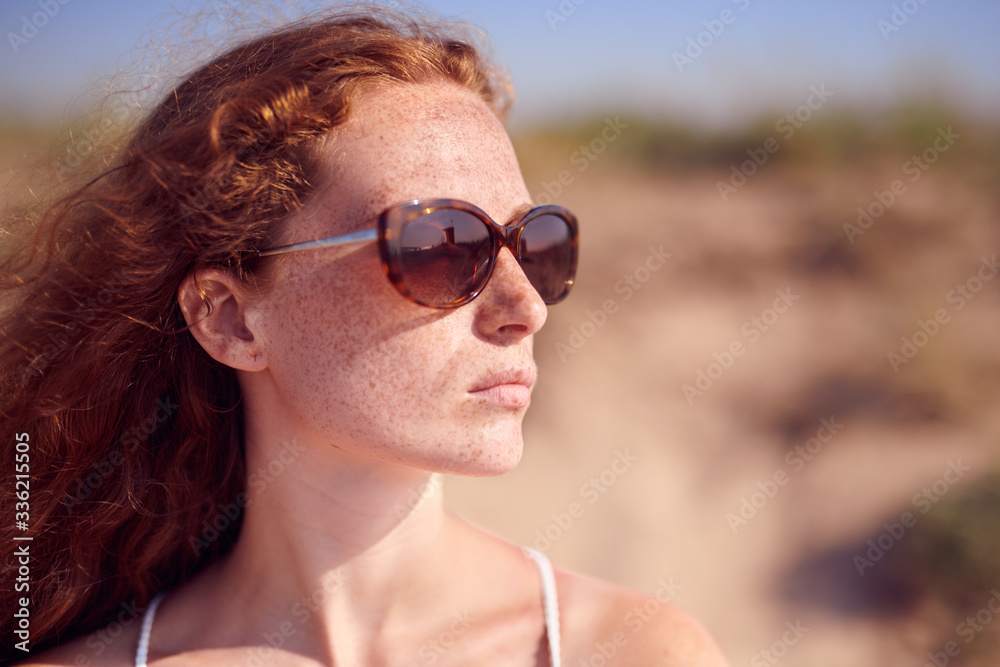 Beautiful red haired girl in sunglasses looking at side. Beautiful red haired girl in sunglasses looking at side.