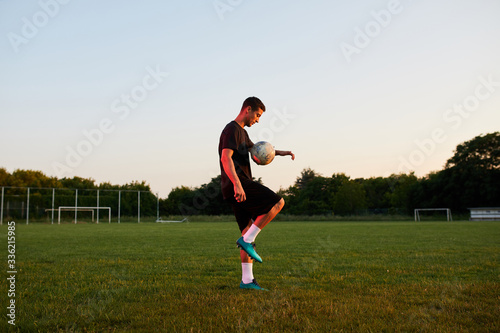 Footballer doing tricks on the pitch.