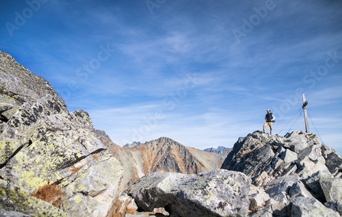 Mature man with backpack hiking in mountains in autumn.
