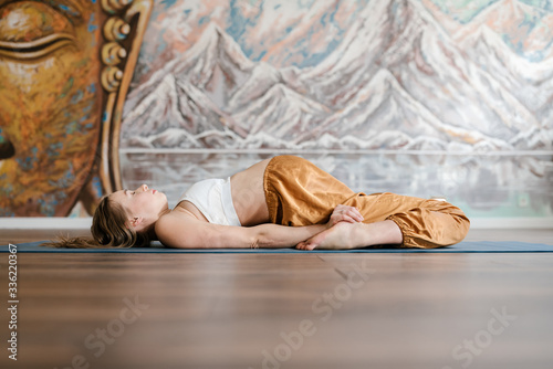 Pregnant lying in relaxed supta virasana pose photo