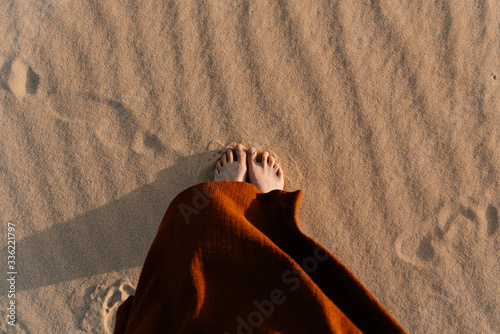 Woman's feet standing on hot sand in desert. photo