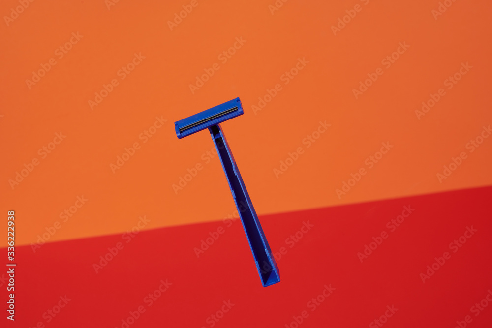 Blue Disposable Razors on Red and Orange Blue Disposable Razors on Red and Orange