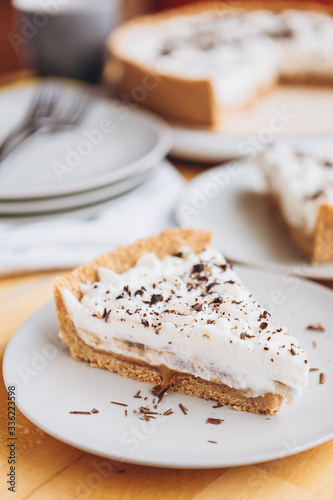 appetizing slice of sand-based dessert with white cream cheese and banana stuffing sprinkled with grated chocolate