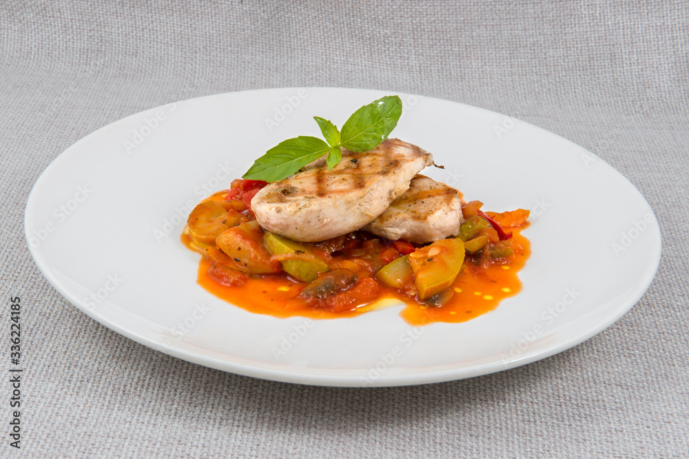 Grilled chicken meatballs with stewed vegetables on a large round plate in the background Grilled chicken meatballs with stewed vegetables on a large round plate in the background