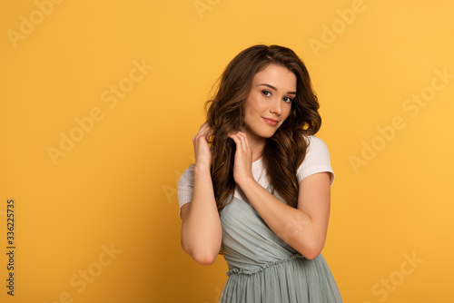 beautiful smiling spring girl with long hair on yellow