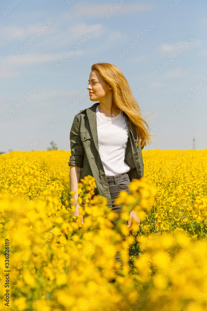 Young woman in yellow blooming field Young woman in yellow blooming field