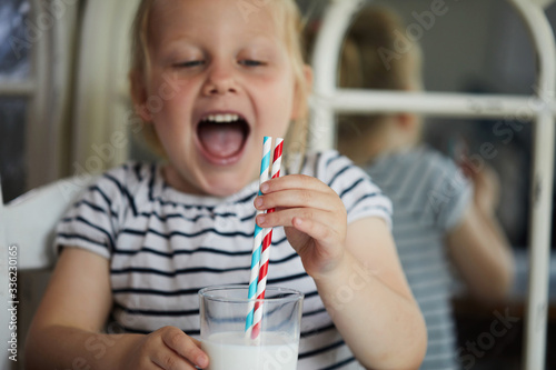 Child drinking milk through a paper straw photo