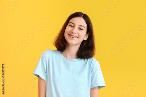 Teenage girl with dental braces on color background photo
