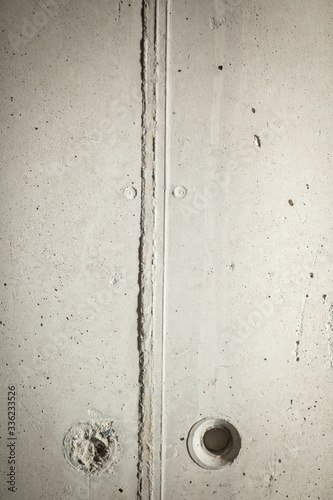 Raw architectural concrete structure with typical seams and mounting holes.