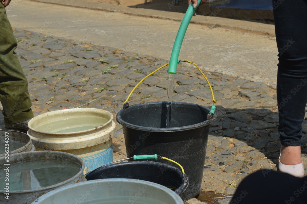 fill water into a bucket using a plastic hose fill water into a bucket using a plastic hose
