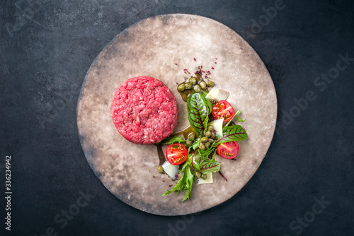 Quadro su tela Gourmet tartar raw from beef fillet with lettuce, tomatoes and parmesan with cap