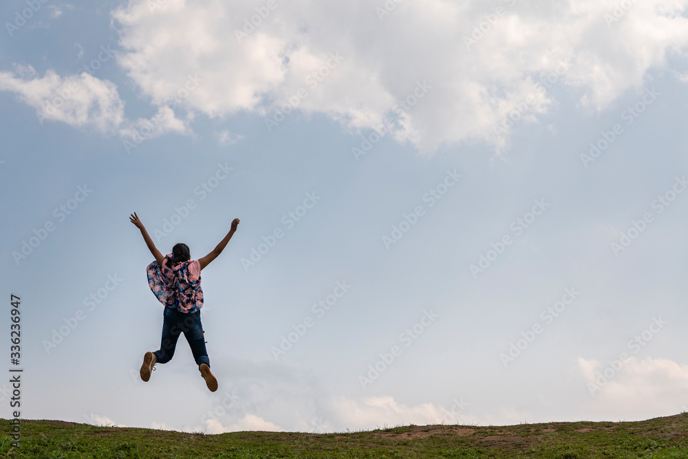 Teenage girl jumping in a vast landscape Teenage girl jumping in a vast landscape