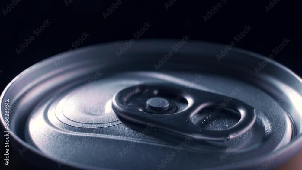 A can of carbonated drink rotates on a dark background. Macro. The play of light and shadow A can of carbonated drink rotates on a dark background. Macro. The play of light and shadow