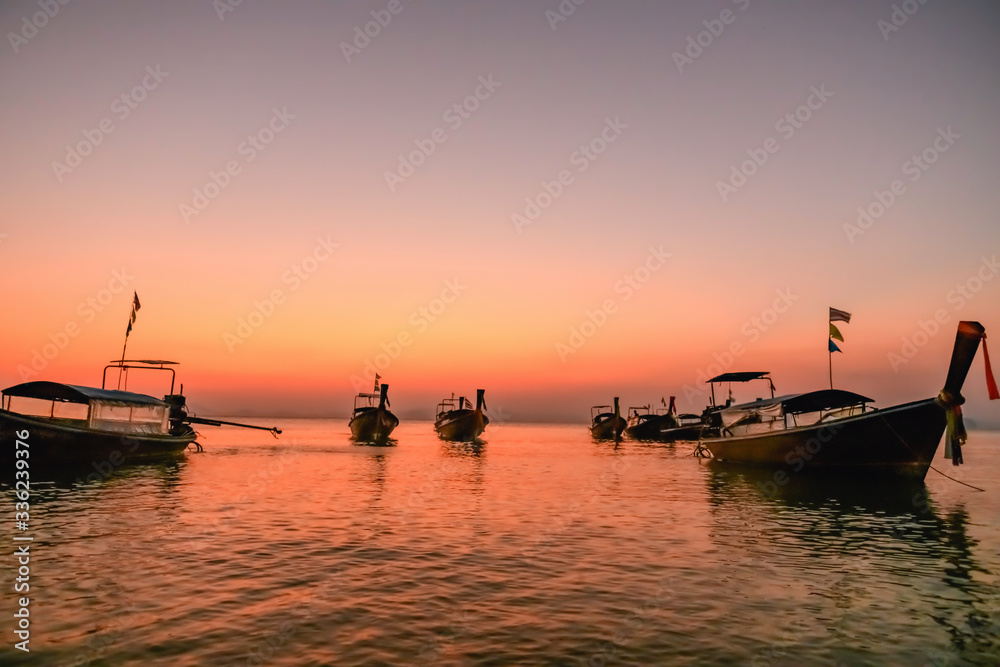 Boats silhouettes at sea surface sunset light