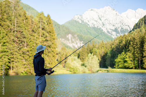 Man fishing at lake in a beautiful green nature