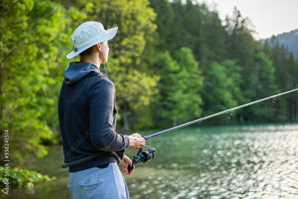 Man fishing at lake in a beautiful green nature Man fishing at lake in a beautiful green nature