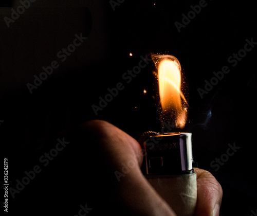 hand holding lighter black background 