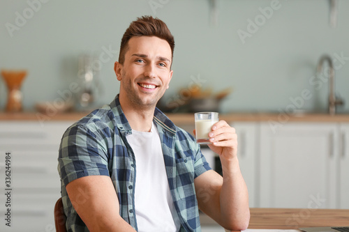 Young man drinking milk in ...