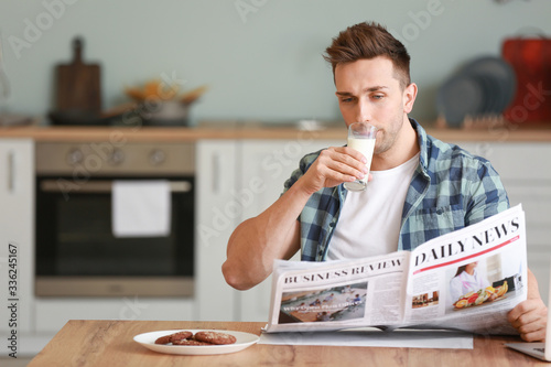 Young man reading newspaper...