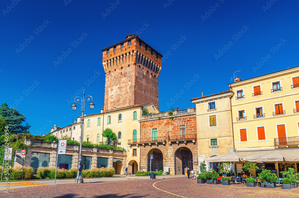 Porta Castello Tower Torre and Gate Terrazza Torrione brick building in old historical city centre of Vicenza city, street restaurant, street light, blue sky background, Veneto region, Italy