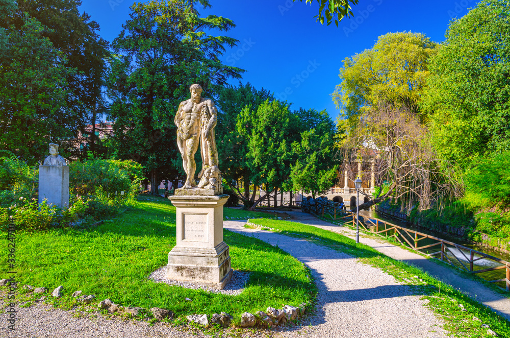 Farnese Hercules (Ercole Farnese) ancient statue of Hercules in Salvi gardens park with green trees and lawn, Valmarana Lodge building, historical city centre of Vicenza city, Veneto region, Italy Farnese Hercules (Ercole Farnese) ancient statue of Hercules in Salvi gardens park with green trees and lawn, Valmarana Lodge building, historical city centre of Vicenza city, Veneto region, Italy