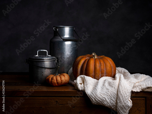 Pumpkin, tin cans and cloth on wood