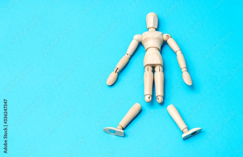 Wooden man mannequin lying without legs on a blue background. Concept for prosthesis information or about fatigue. Wooden man mannequin lying without legs on a blue background. Concept for prosthesis information or about fatigue.