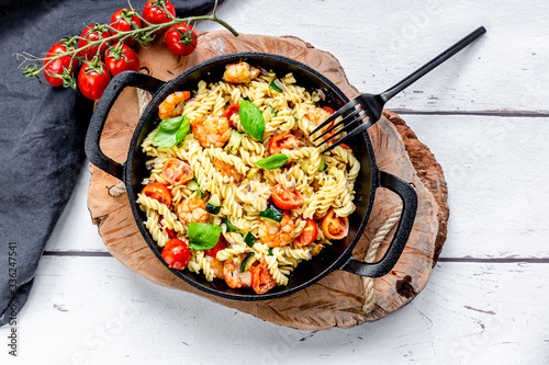 Pan of?ready-to-eat?pasta with tomatoes, shrimps, zucchini and basil photo
