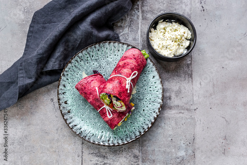 Vegetarian beetroot wraps filled with?tomatoes, red cabbage, corn, iceberg lettuce, cucumbers and cream cheese