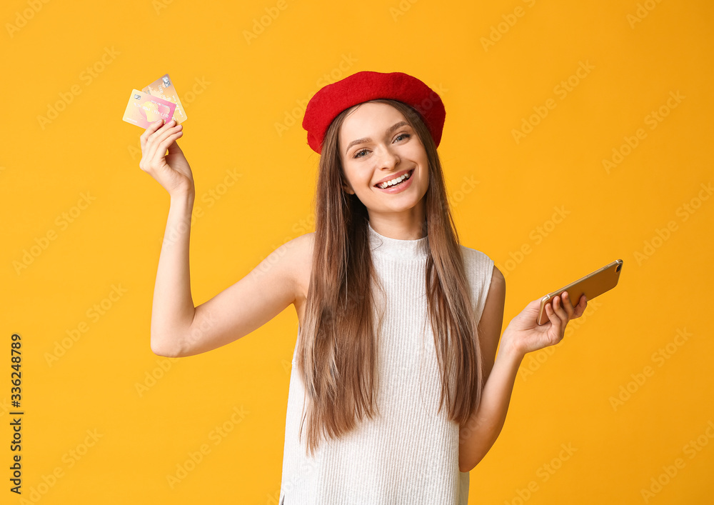 Young woman with mobile phone and credit cards on color background. Online shopping concept Young woman with mobile phone and credit cards on color background. Online shopping concept