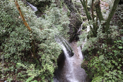 Beautiful landscape of cascade falls over mossy rocks, stones cover with moss, in a Mountain in Sichuan, China