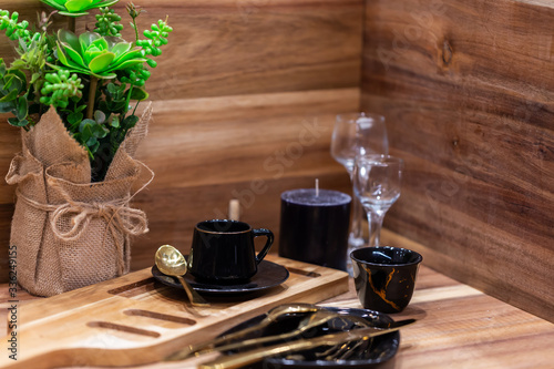 Coffee still life with cup of coffee. black vintage cups of black coffee on old wooden table. Still life with coffee  flowers and dishes of black color on the background of old wooden planks
