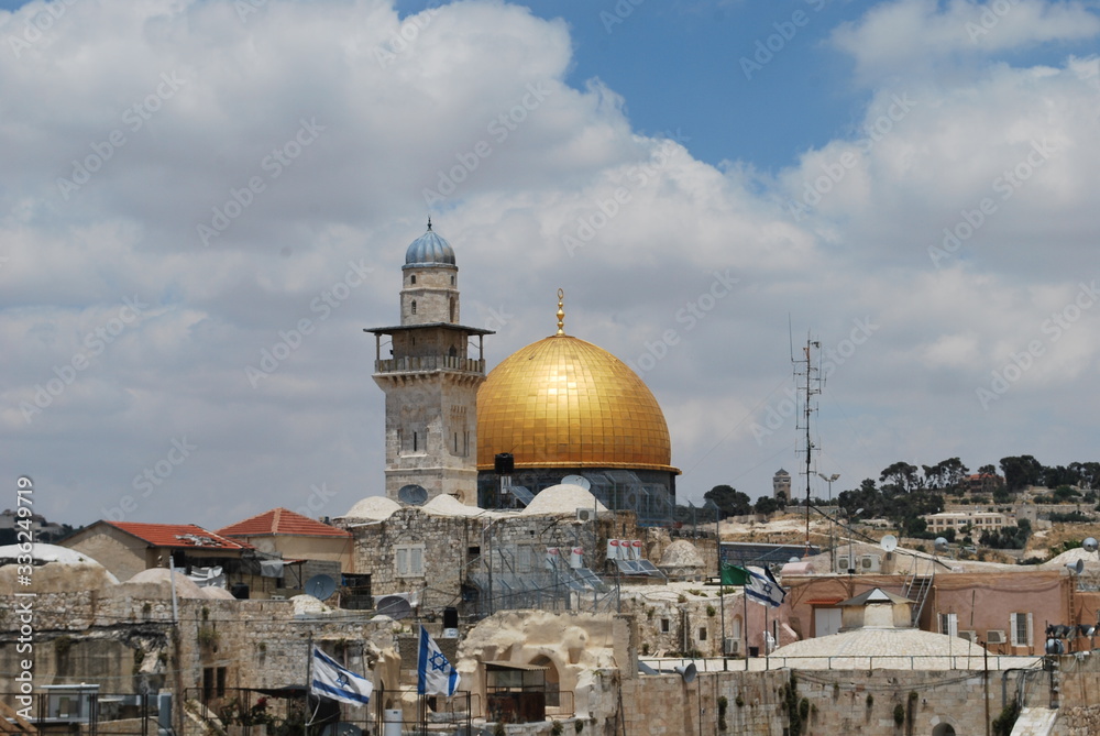 View toward the Dome of the Rock in Jerusalem past a minaret and rooftops of the old city.

